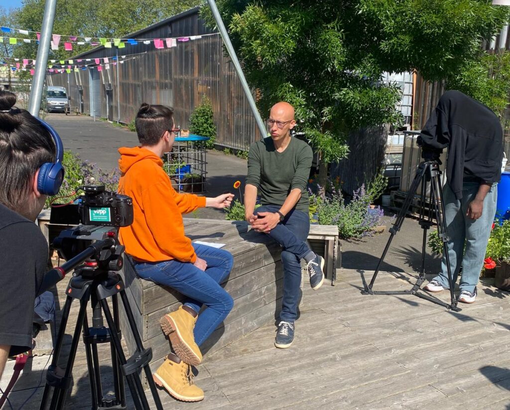 Jeune en train d'interviewer une personne dans le cadre d'un accompagnement de projet vidéo du vlipp